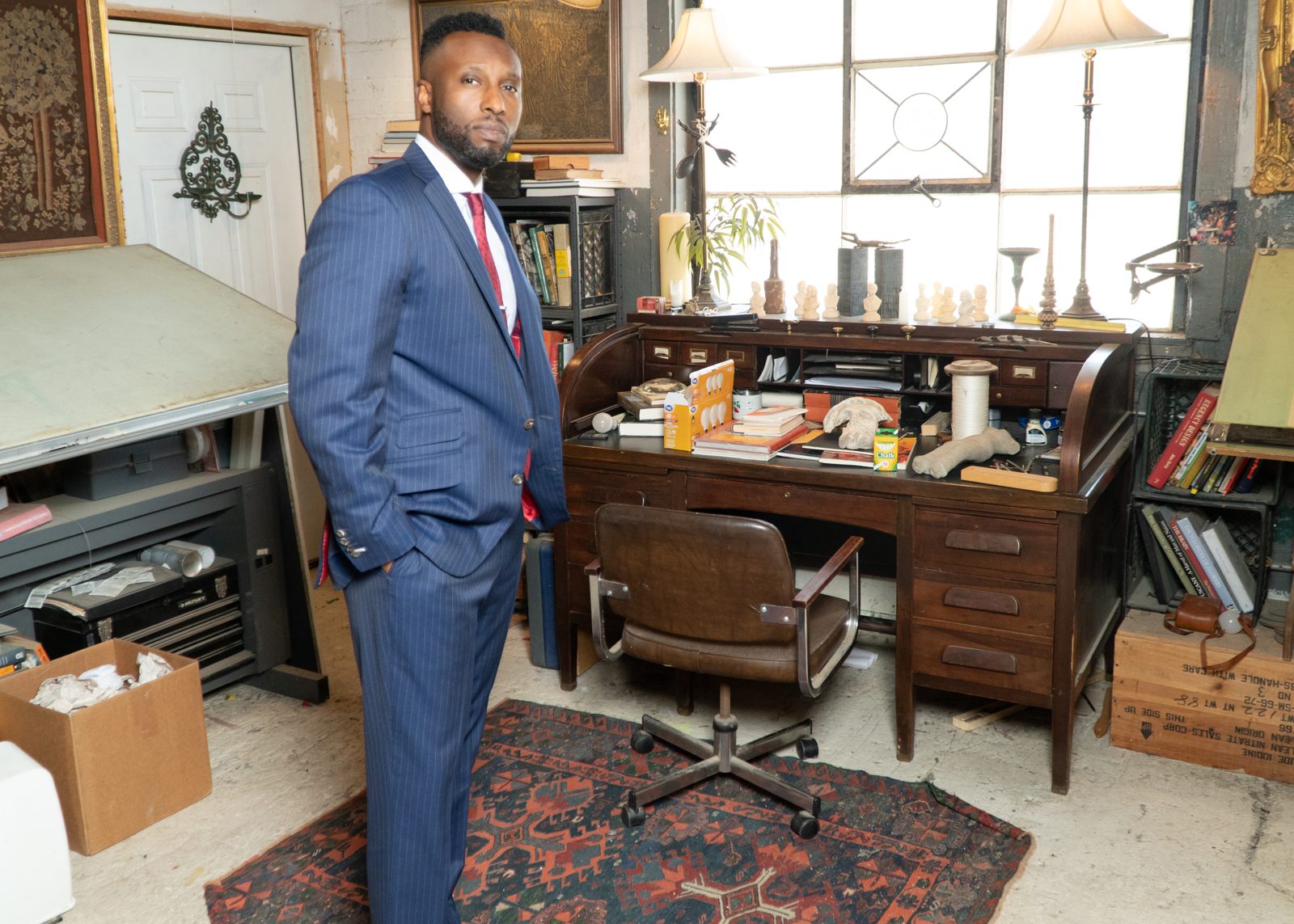 Ronnell Richards at a vintage desk in a tailored suit